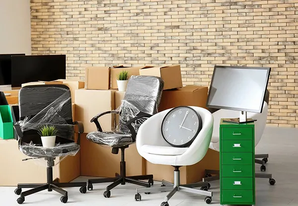 Office chairs and boxes, depicting commercial unpacking services.