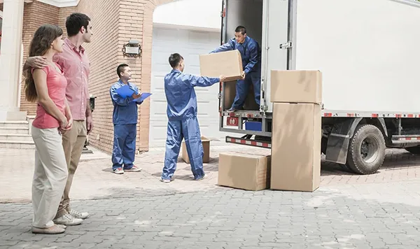 Movers unloading boxes from a truck, representing custom unloading services.
