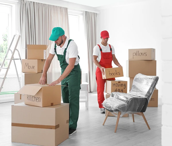 Movers unpacking boxes and furniture in a furnished living room.