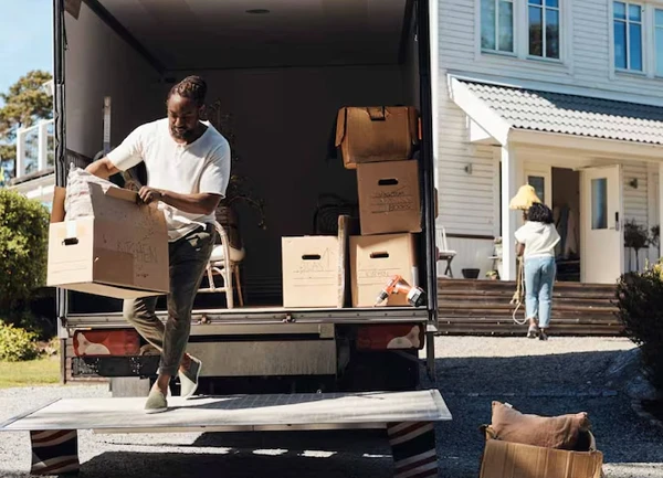 Mover using a dolly to move boxes during a residential relocation.