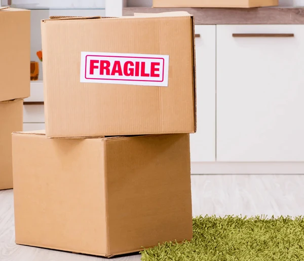 Stack of cardboard boxes, one clearly labeled "FRAGILE" in red.