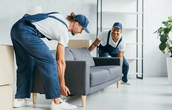 Movers lifting heavy furniture, showing heavy item loading services.