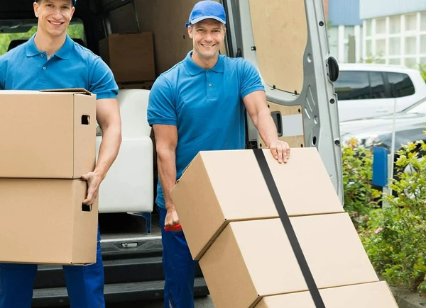 Two movers loading a stack of boxes onto a truck with care and efficiency.